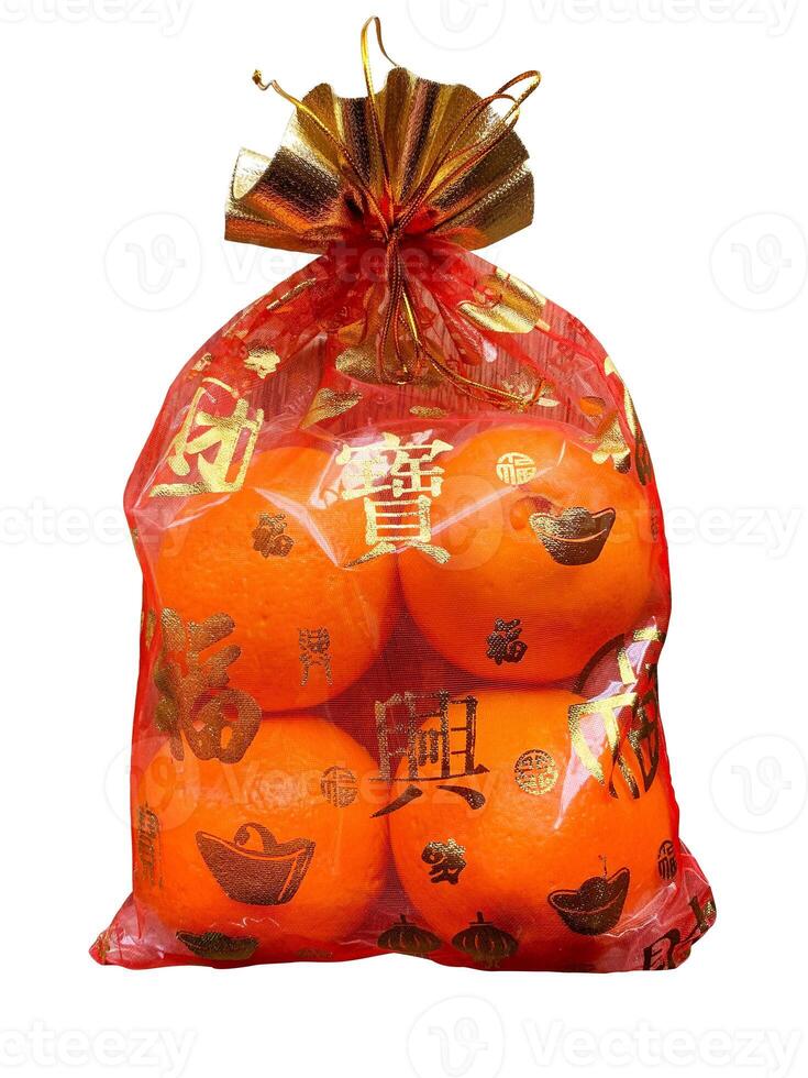 Oranges in a Chinese cloth bag isolated on white background. Oranges are auspicious fruits according to Chinese beliefs because their skin color is like gold. And in Chinese it also means happiness. photo