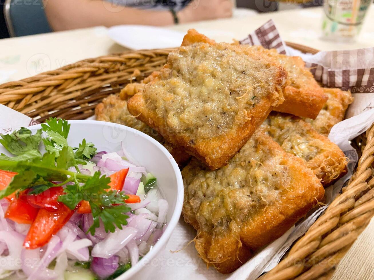 Closeup Thai fusion snack fried bread with minced pork and Side dishes spread made from onions, red peppers, topped with vinegar. photo