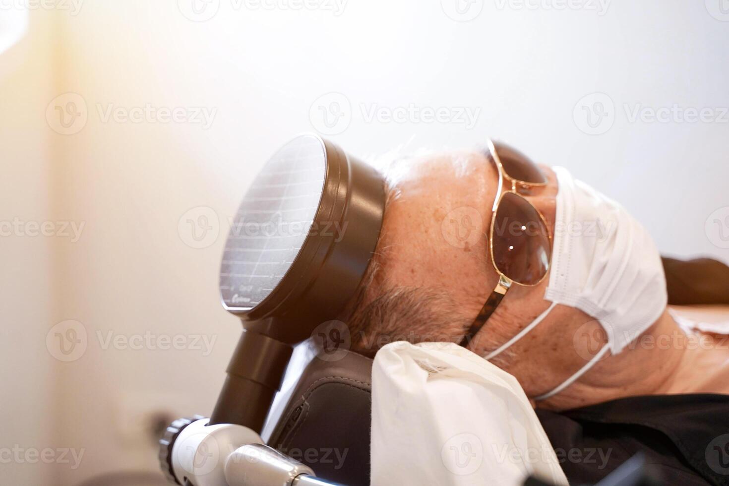 Electrical muscle stimulation on elderly patient's head. EMS is the elicitation of muscle contraction using electric impulses . photo