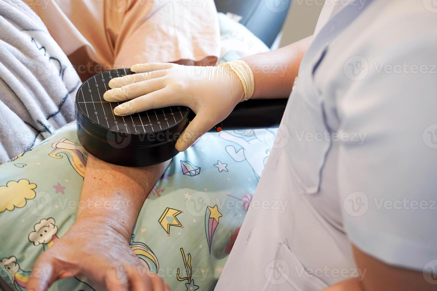 Closeup hands of doctor using electrical muscle stimulation on arm elderly patients in nursing homes photo