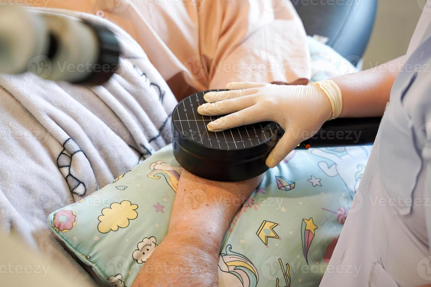 Closeup hands of doctor using electrical muscle stimulation at arm elderly patients in nursing homes photo