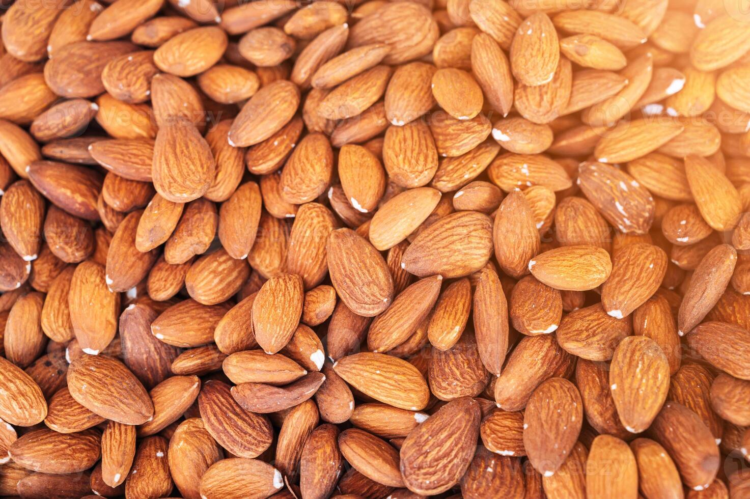 background with orange peeled almond kernels on market counter close-up photo