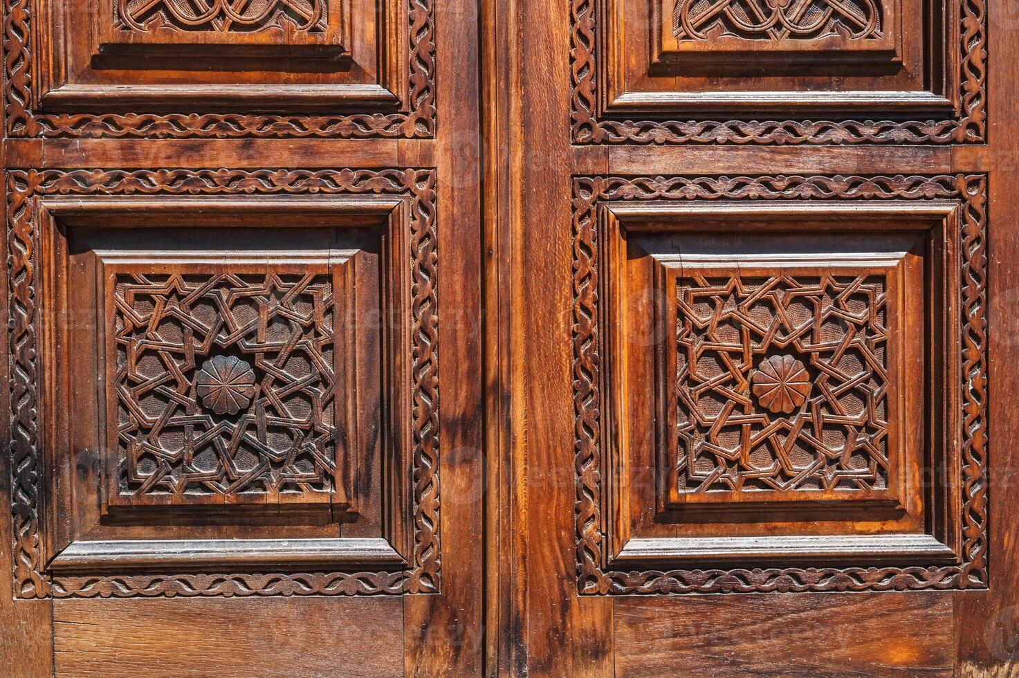 Oriental tajik kandakori patterns arabesque ornament on an old wooden carved door in Tajikistan close-up photo