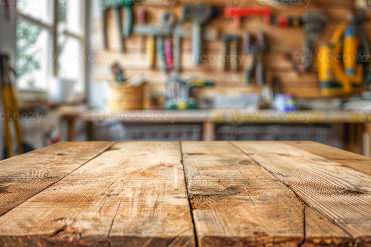 Empty wooden table in the foreground and blurred background with carpenter's tools on the wall. photo