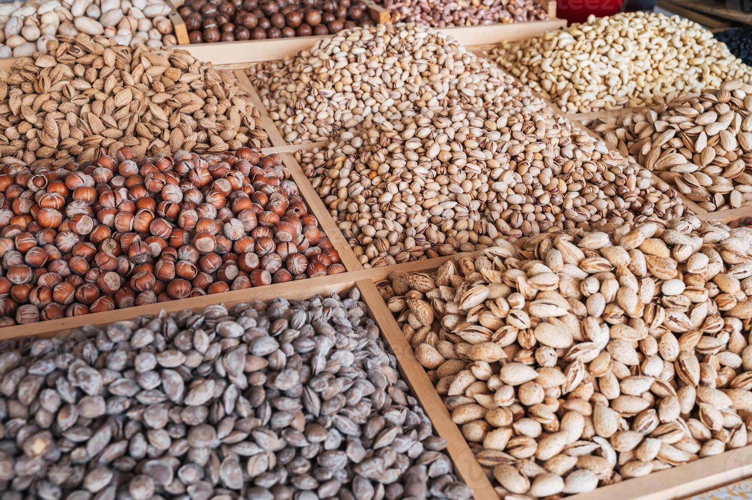 assortment of different variety nuts on counter at oriental farmers market. Almonds, pistachios, hazelnuts, macadamia, pecans and cashews photo