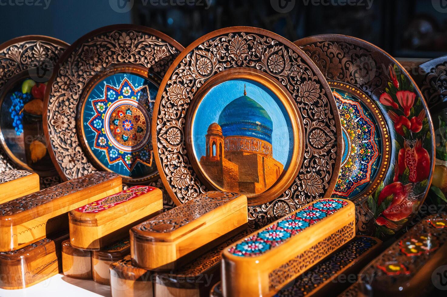 Uzbek wooden gift plates and caskets with wood carvings hand-painted asian patterns in souvenir shop of Uzbekistan photo