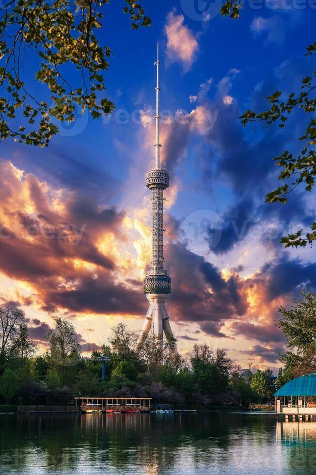 television TV tower in Tashkent in Uzbekistan with a reflection in the water of river under a beautiful blue sky in spring at sunset photo