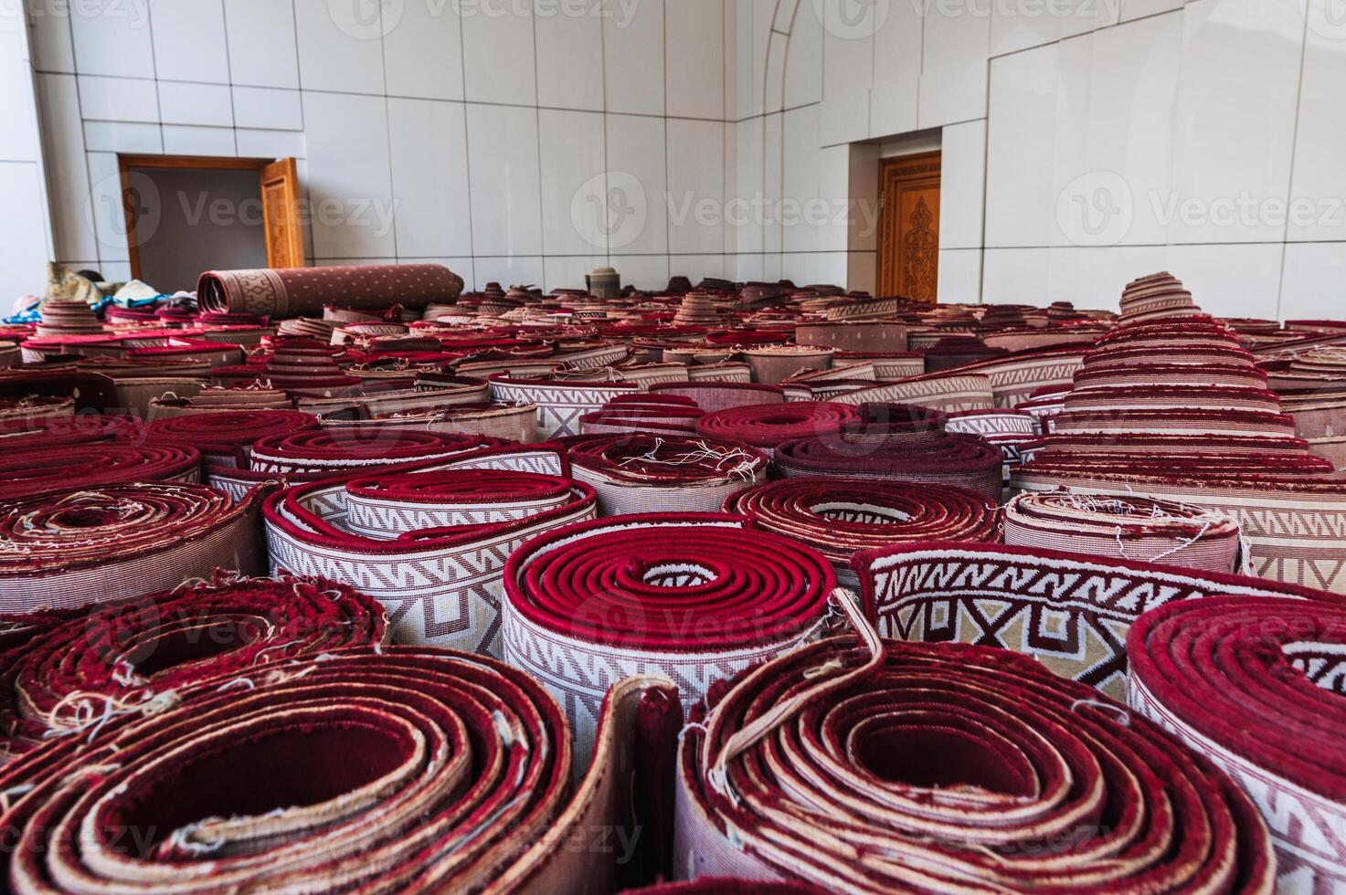stack of rolled up traditional vintage Uzbek red carpets oriental bazaar for sale in Tashkent in Uzbekistan photo