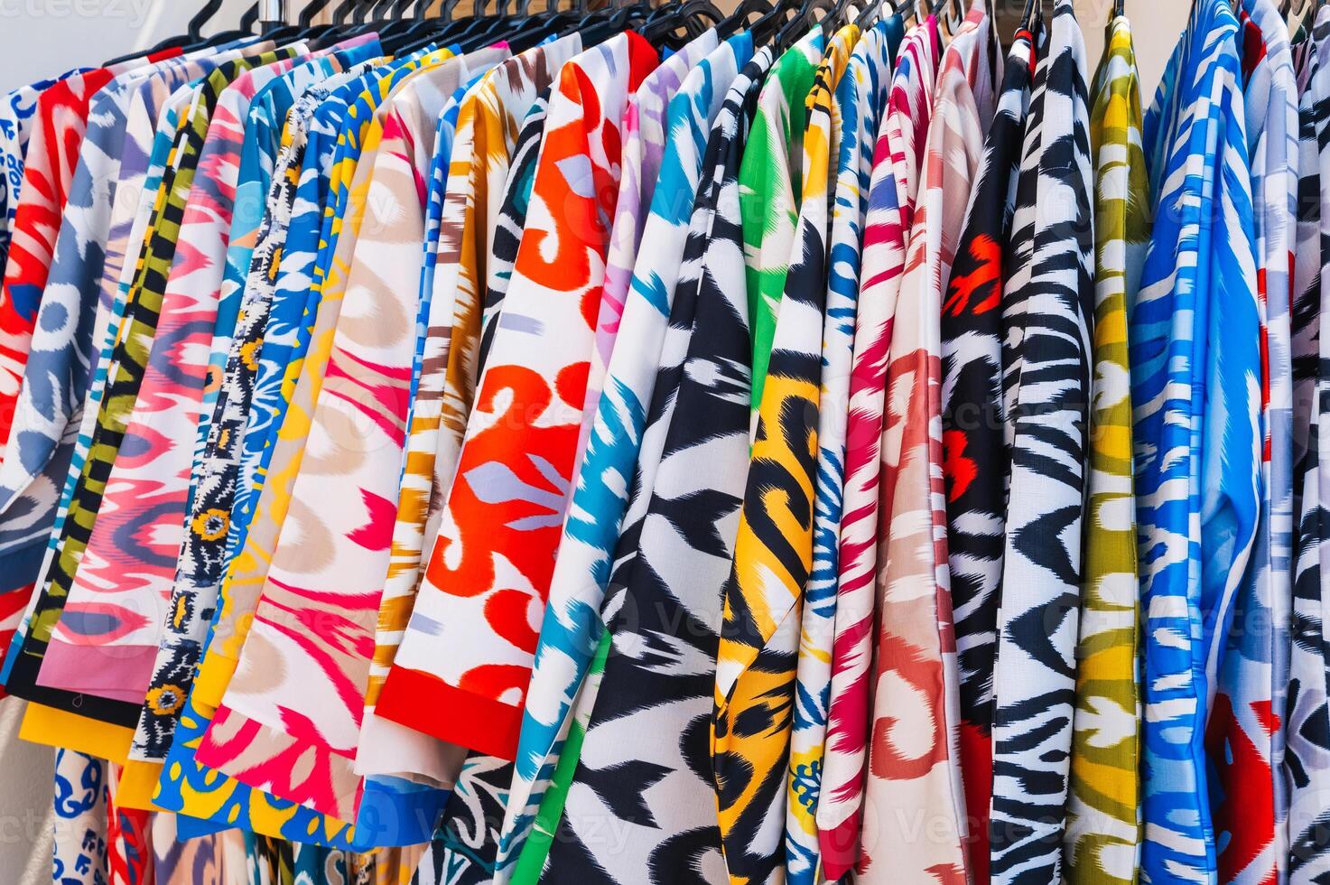 Asian dresses made of silk fabric with bright colorful pattern at oriental bazaar in India close-up photo