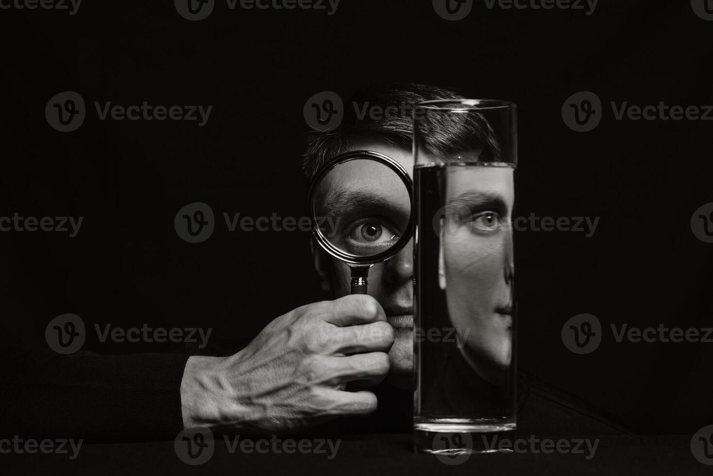 portrait of a man through a magnifying glass and a container of water photo