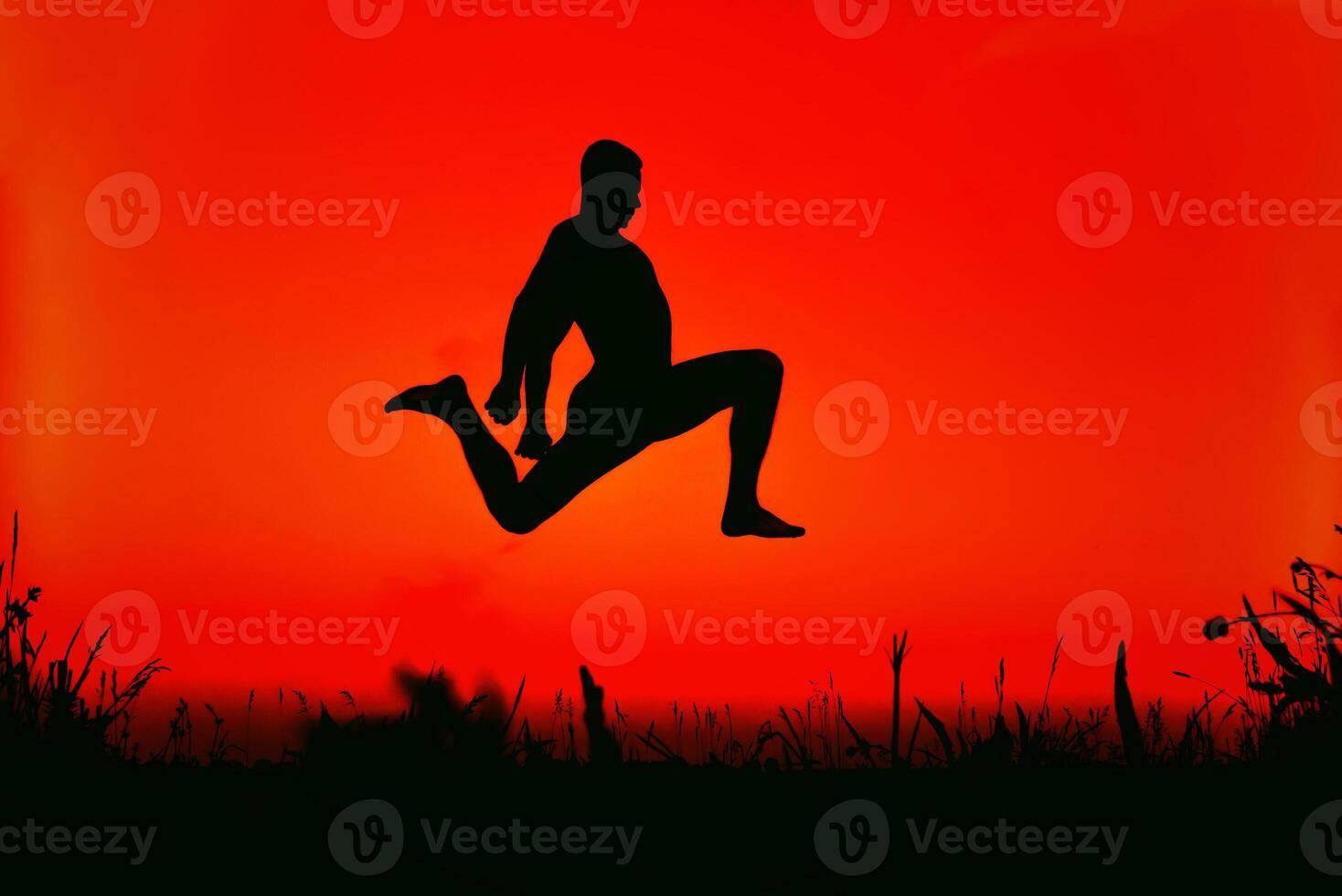 silhouette of a sporty man jumping high in nature photo