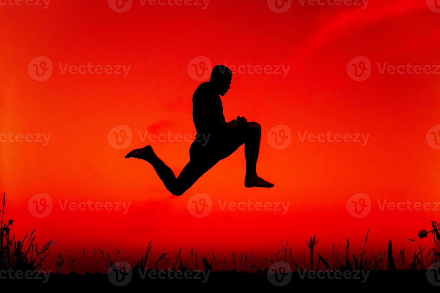 silhouette of a sporty man jumping high in nature photo