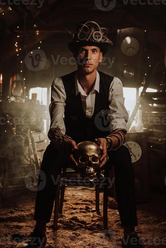 male inventor in a steampunk suit in a top hat with glasses with a golden skull in his hand photo