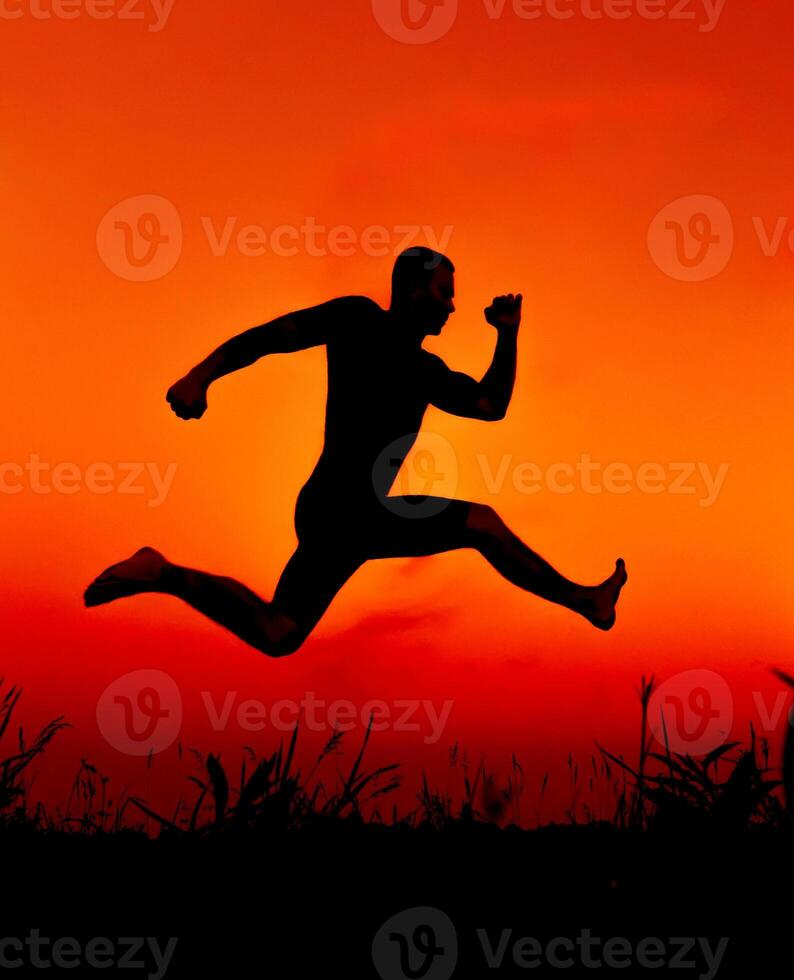 silhouette of a man jumping high in nature in summer photo