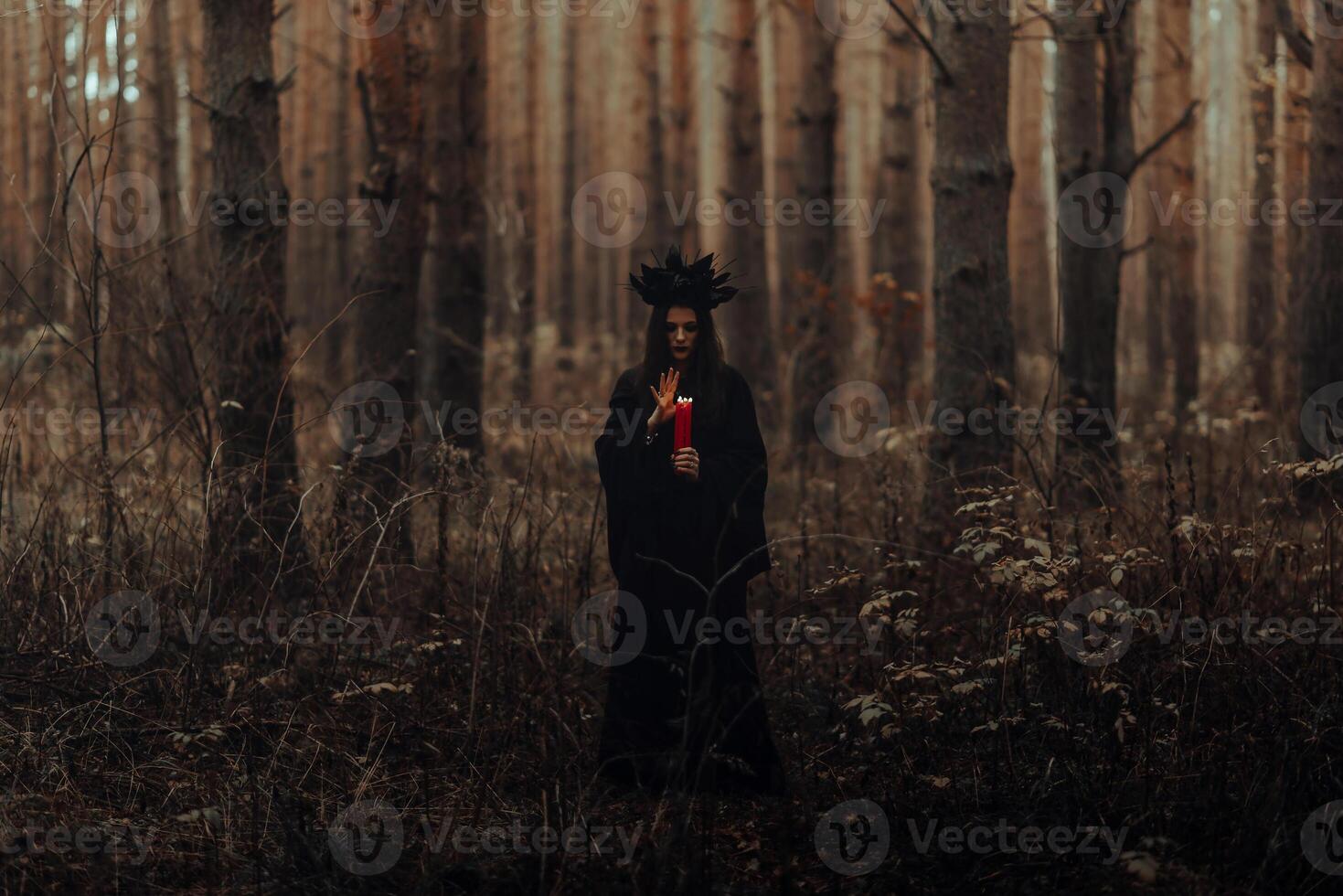 dark terrible witch with candles in her hands performs an occult mystical ritual photo