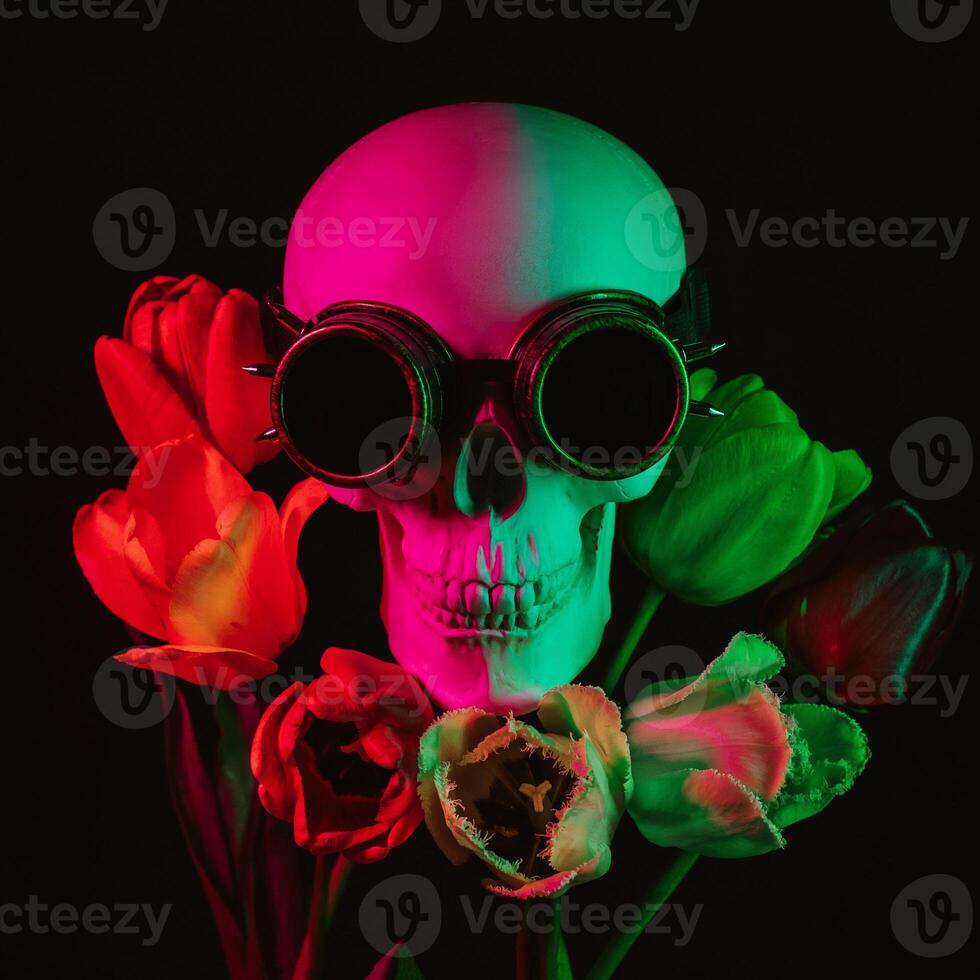 human skull in steampunk glasses in tulip flowers with colored neon light photo
