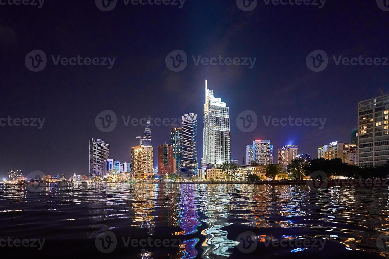 Ho Chi Minh City skyline and the Saigon River. Amazing colorful night view of skyscraper and other modern buildings at downtown. Travel concept photo