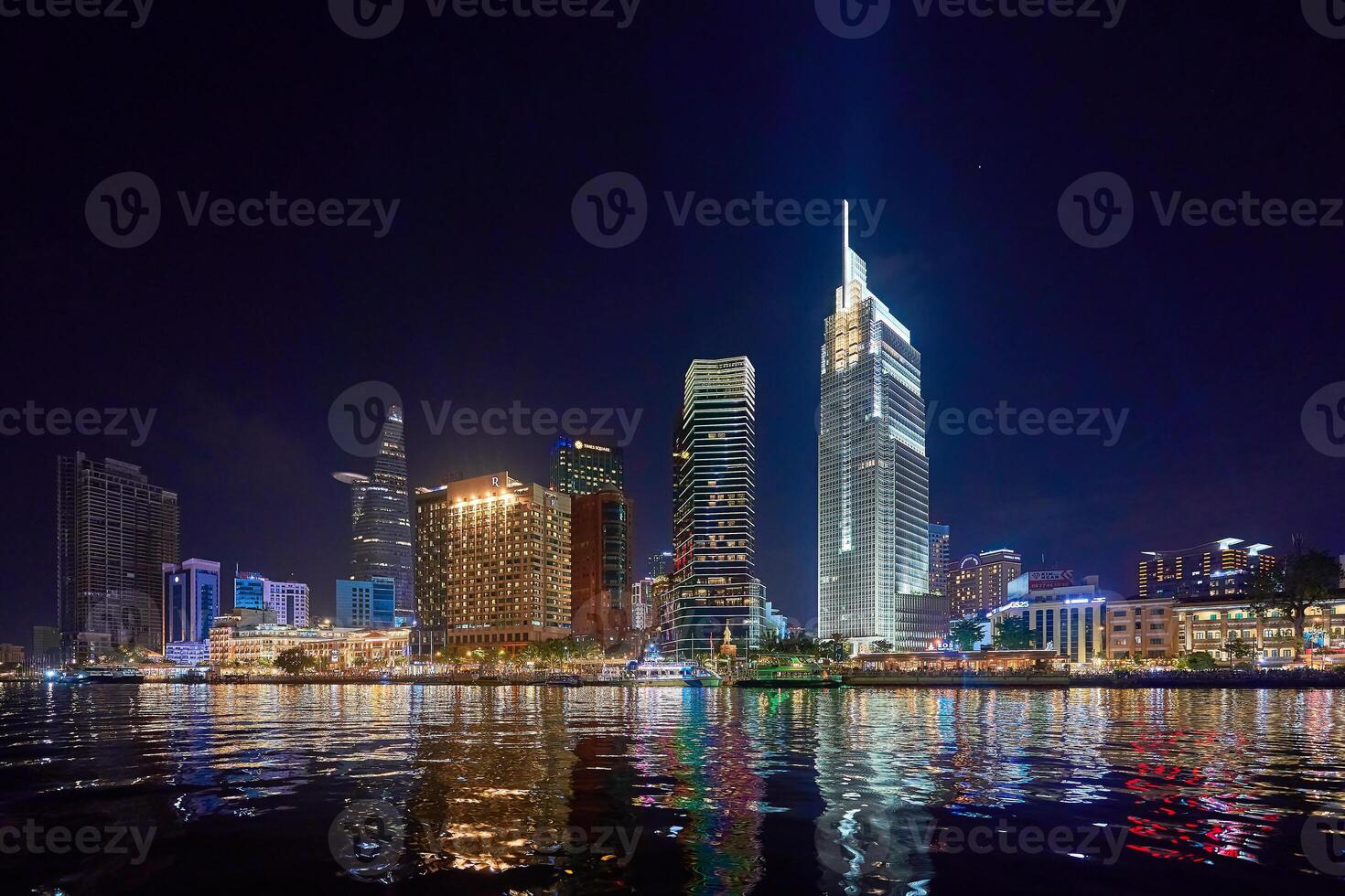 Ho Chi Minh City skyline and the Saigon River. Amazing colorful night view of skyscraper and other modern buildings at downtown. Travel concept photo