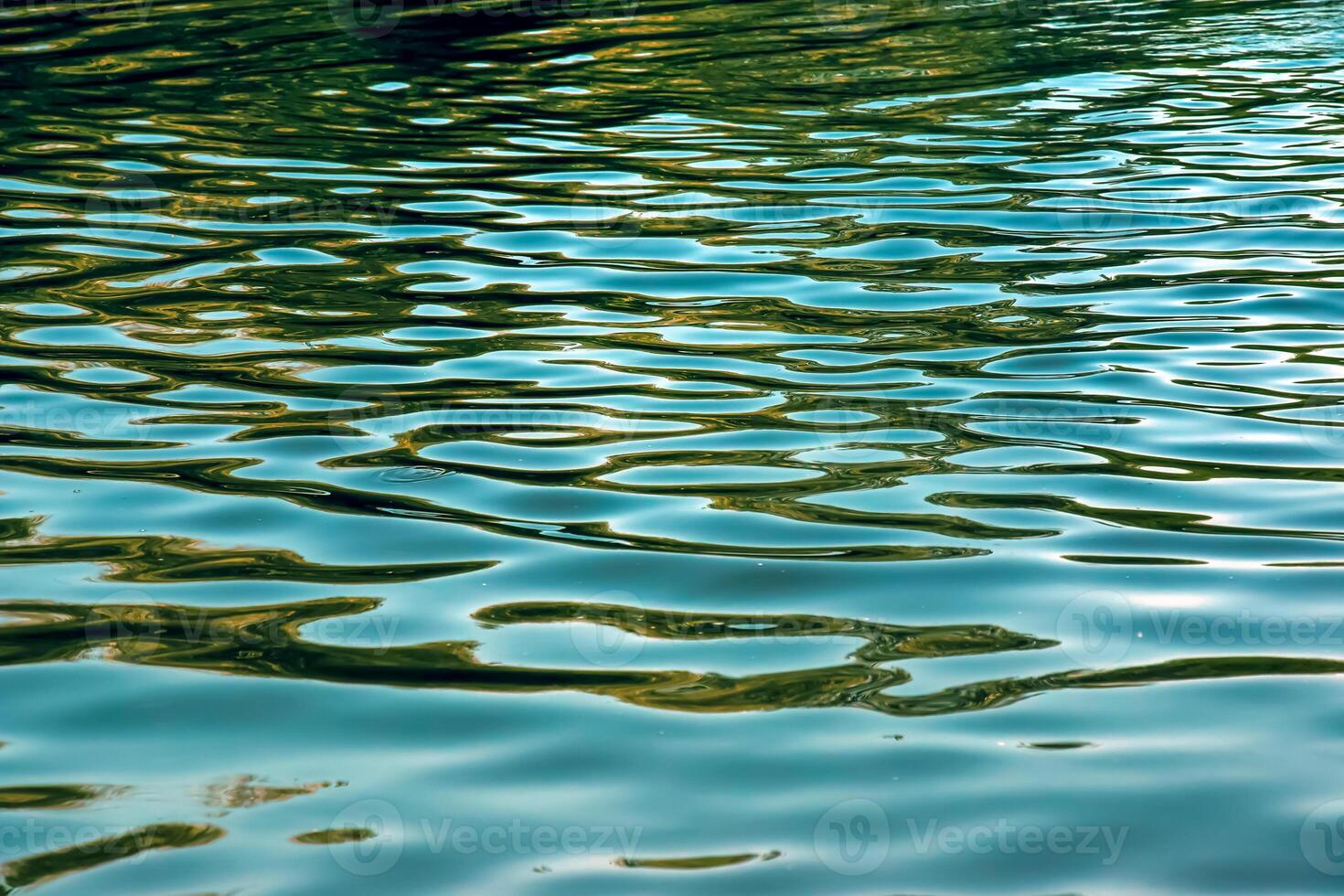 Water ripple texture background. Wavy water surface during sunset, golden light reflecting in the water photo