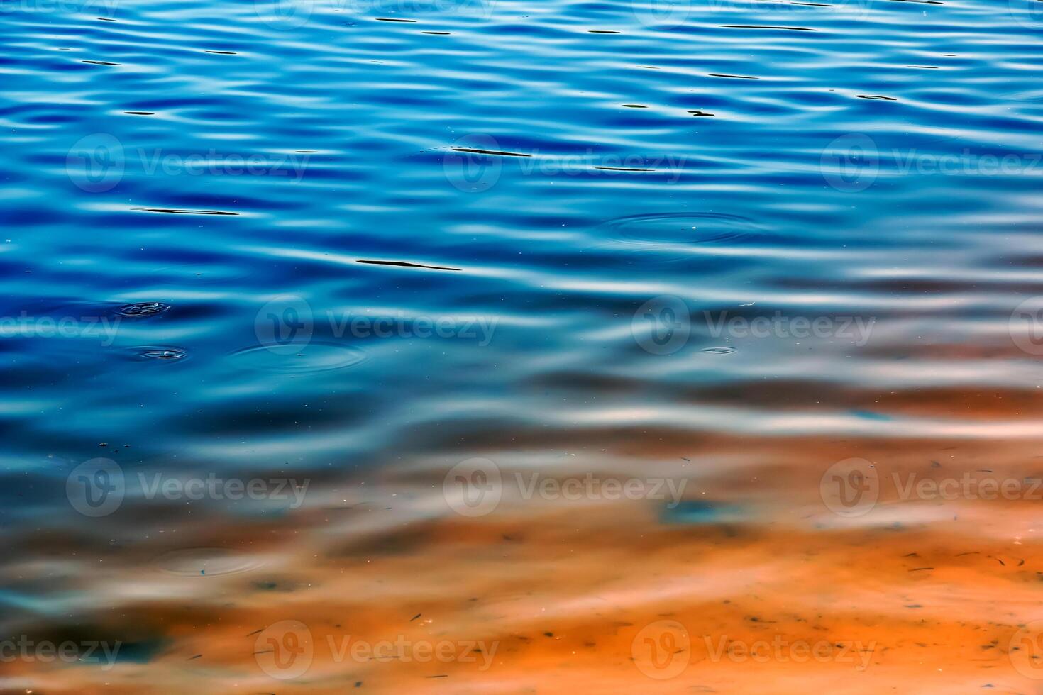 Water ripple texture background. Wavy water surface during sunset, golden light reflecting in the water photo