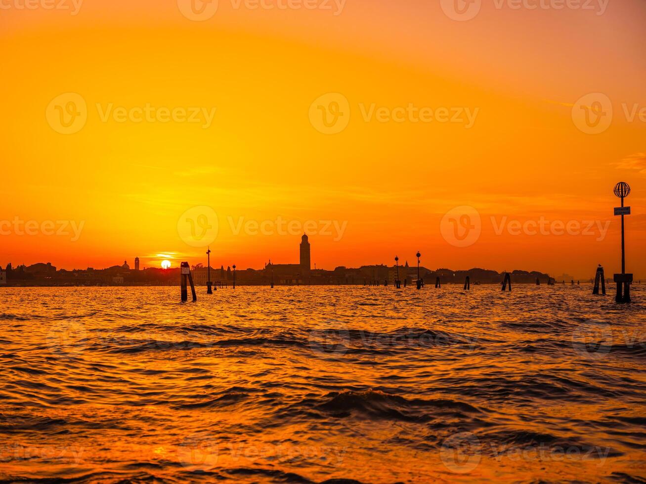 silhouettes of Venice at sunset , view from water photo