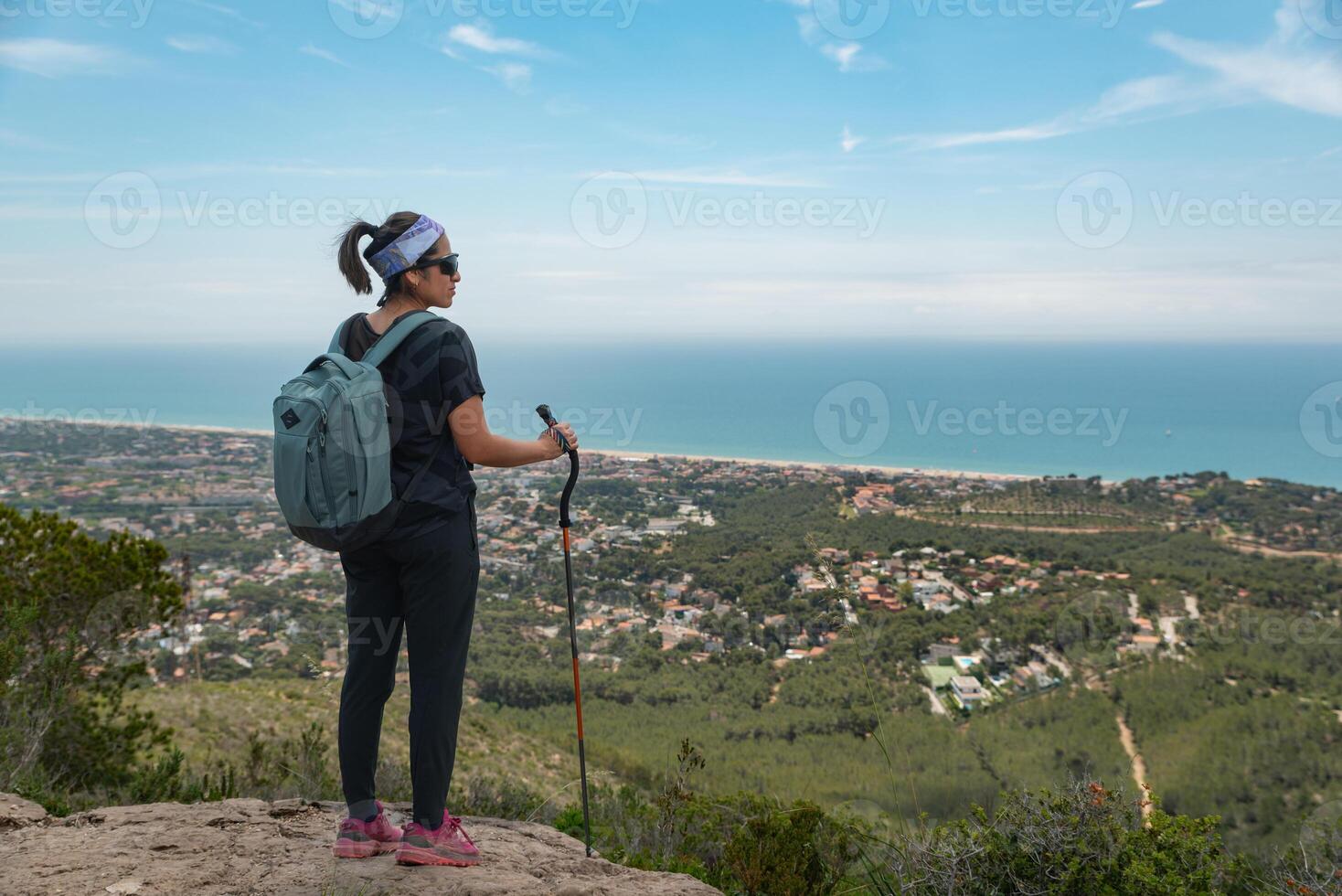 Hiker contemplates the Mediterranean coast while resting from his mountain hike. photo