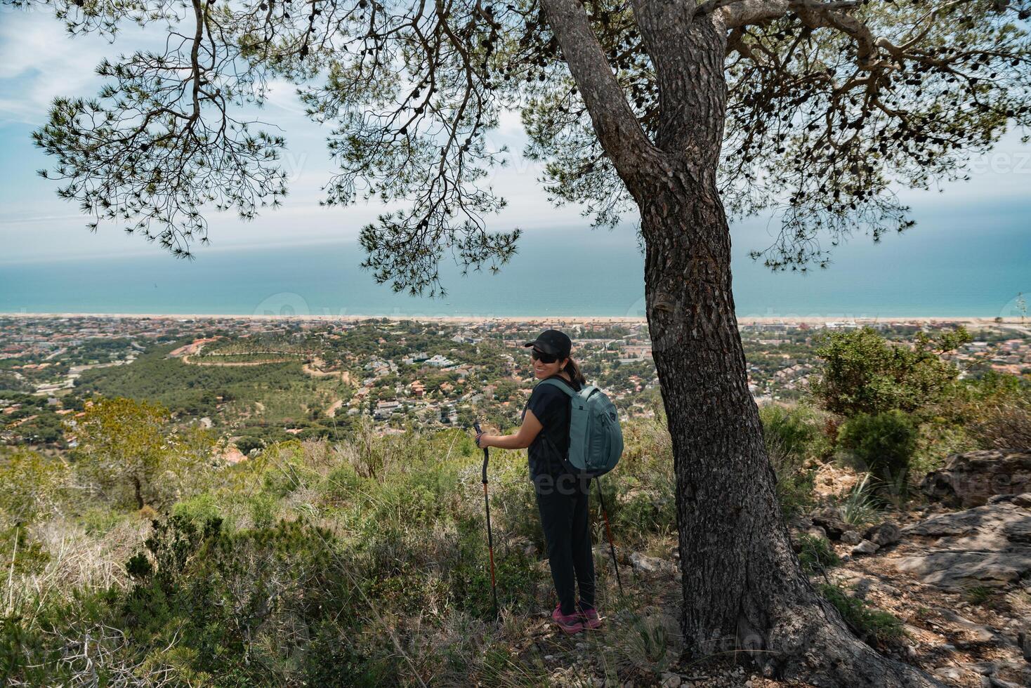 Happy hiker in the mountains and the Mediterranean coast in the background. photo