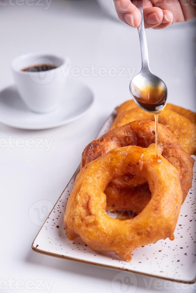 Hand with a spoon adding the honey prepared especially for this dish. photo