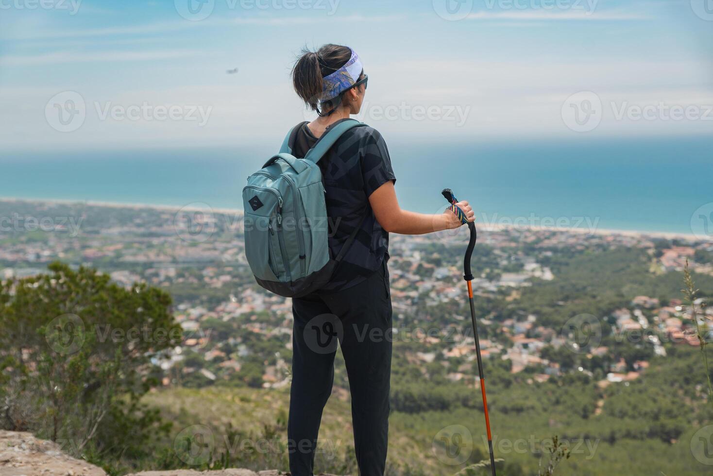 Hiker contemplates the Mediterranean coast while resting from his mountain hike. photo