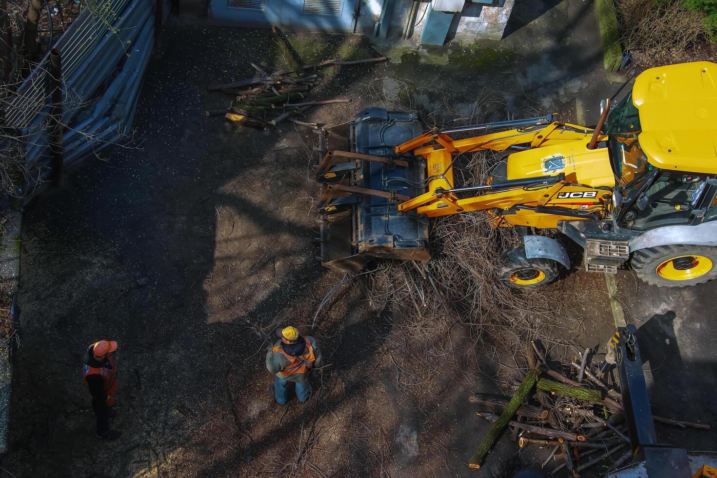 Dnepr, Ukraine - 03.20.2024 A bulldozer collects branches after pruning trees. View from above photo