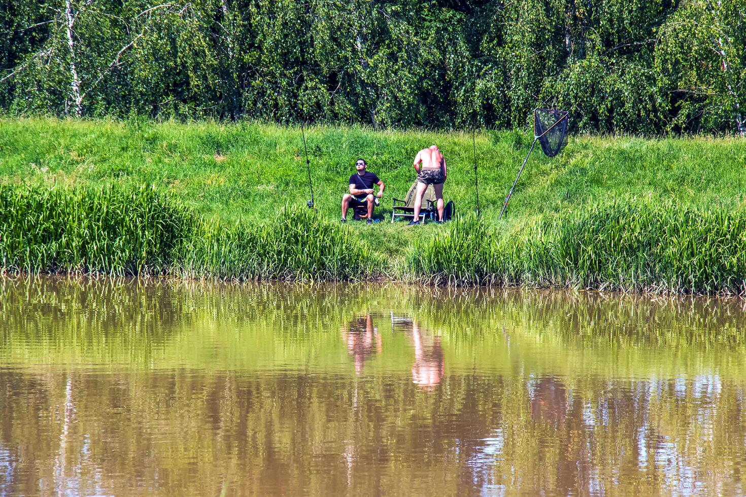 Nitra, Slovakia - 05.27.2024 Fishermen on the banks of the Nitra river. photo