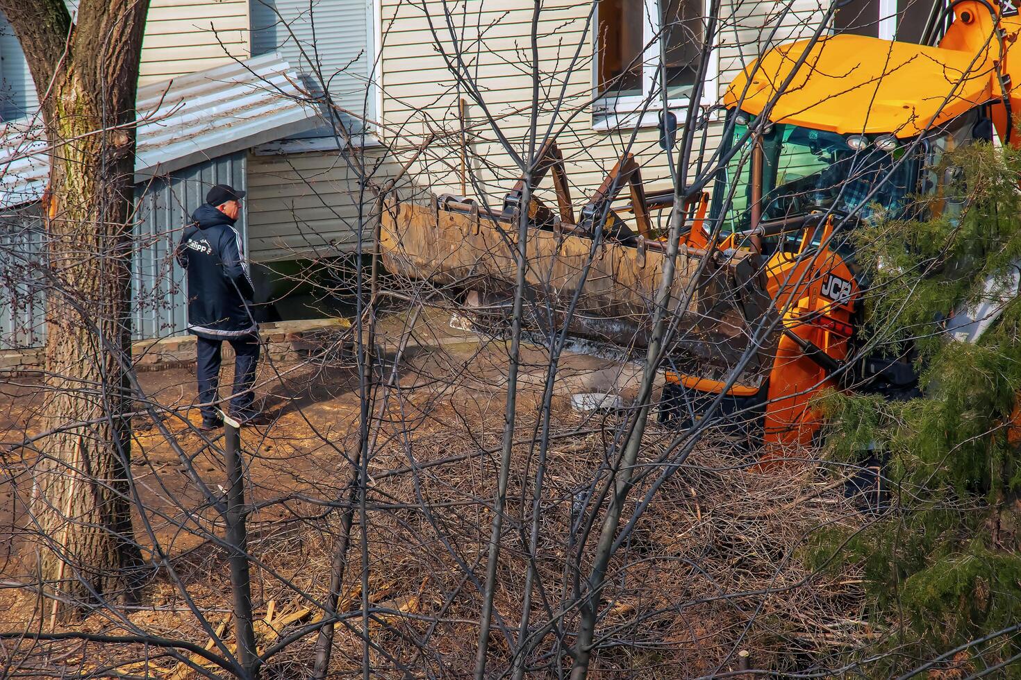 Dnepr, Ukraine - 03.20.2024 A bulldozer collects branches after pruning trees photo
