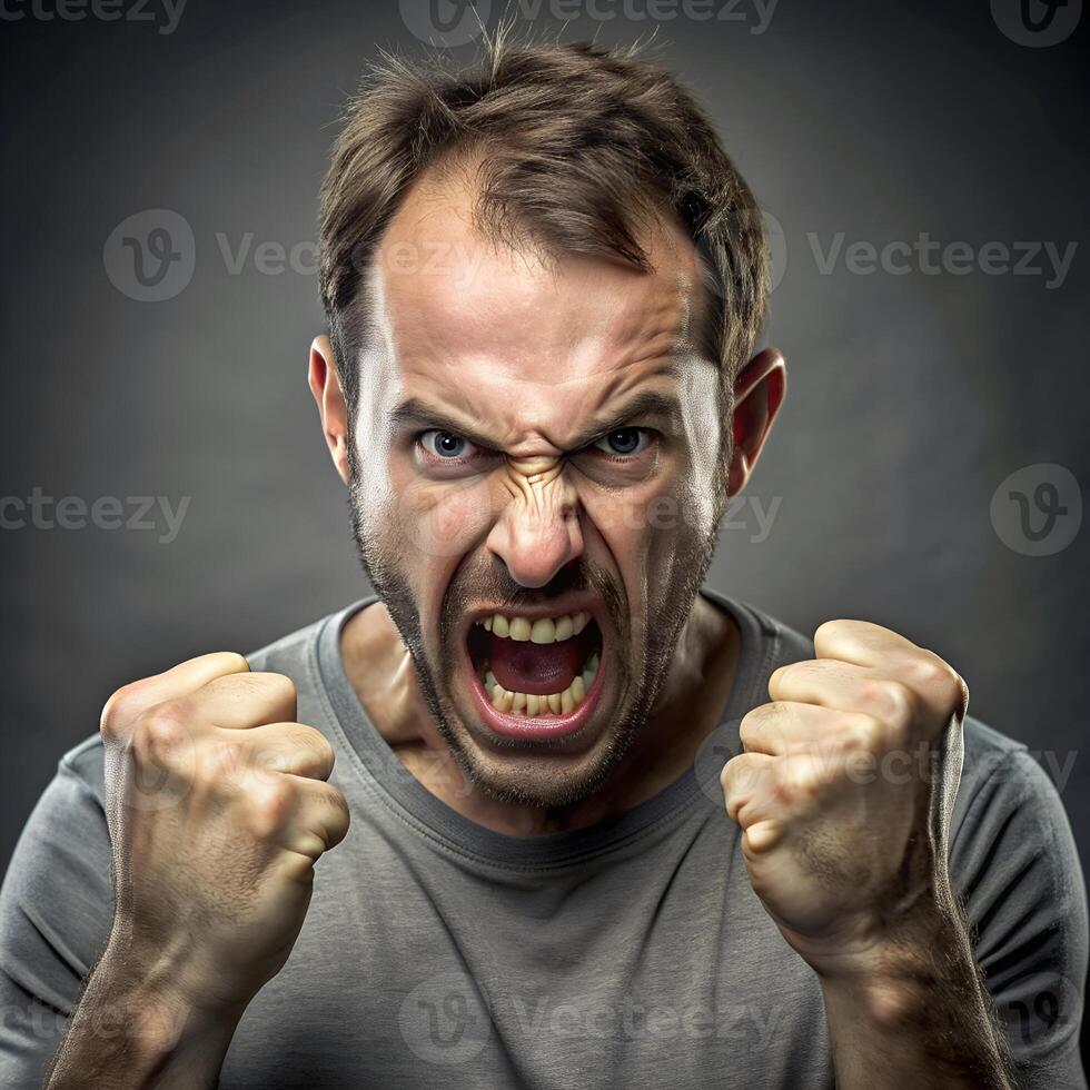 Angry man with clenched fists expressing intense anger and frustration on a dark background photo