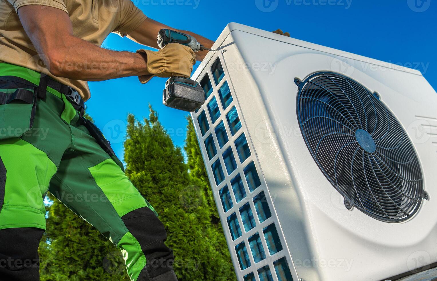 Technician Installing Hat Pump Unit Outdoors photo
