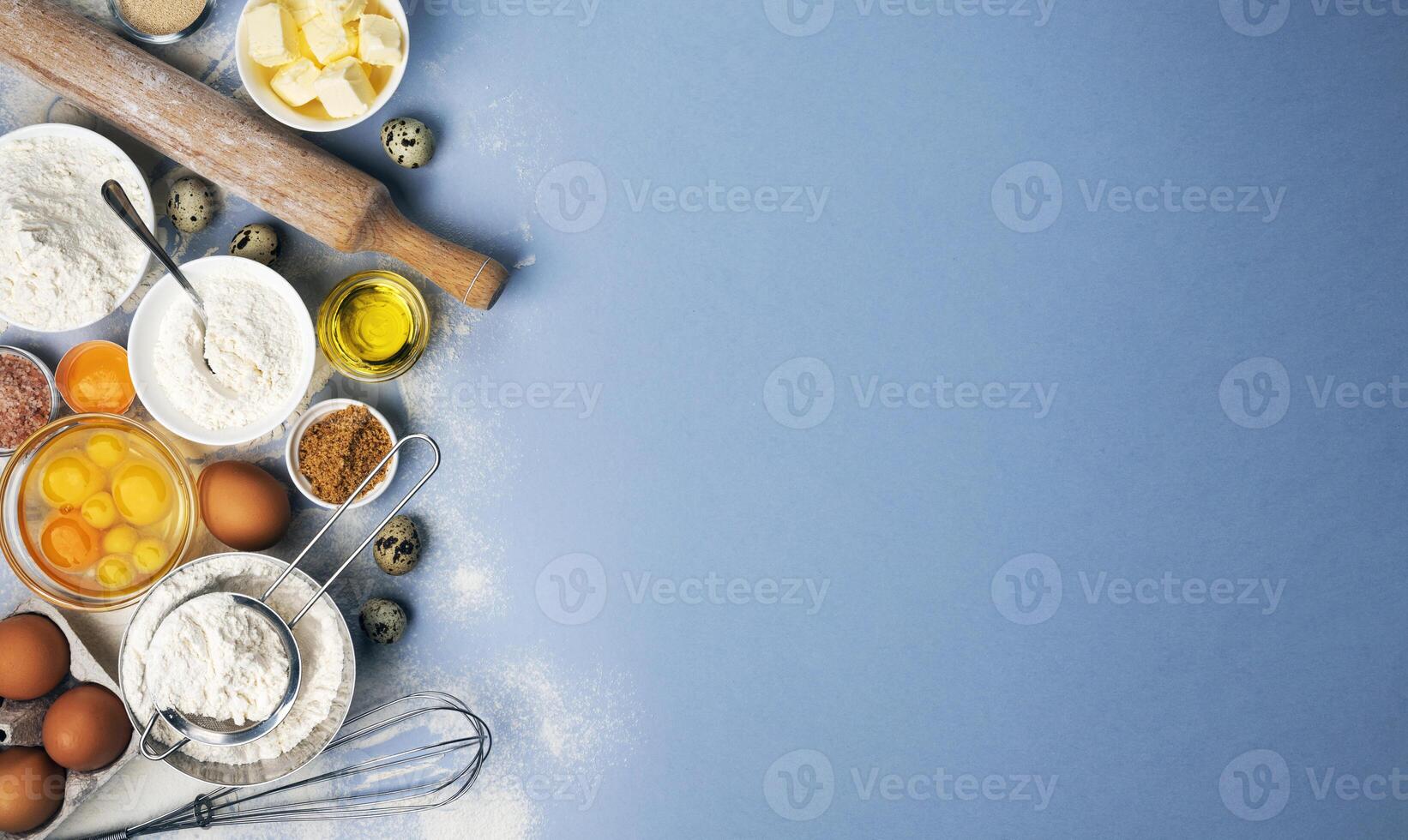 Baking ingredients on blue color background, top view photo