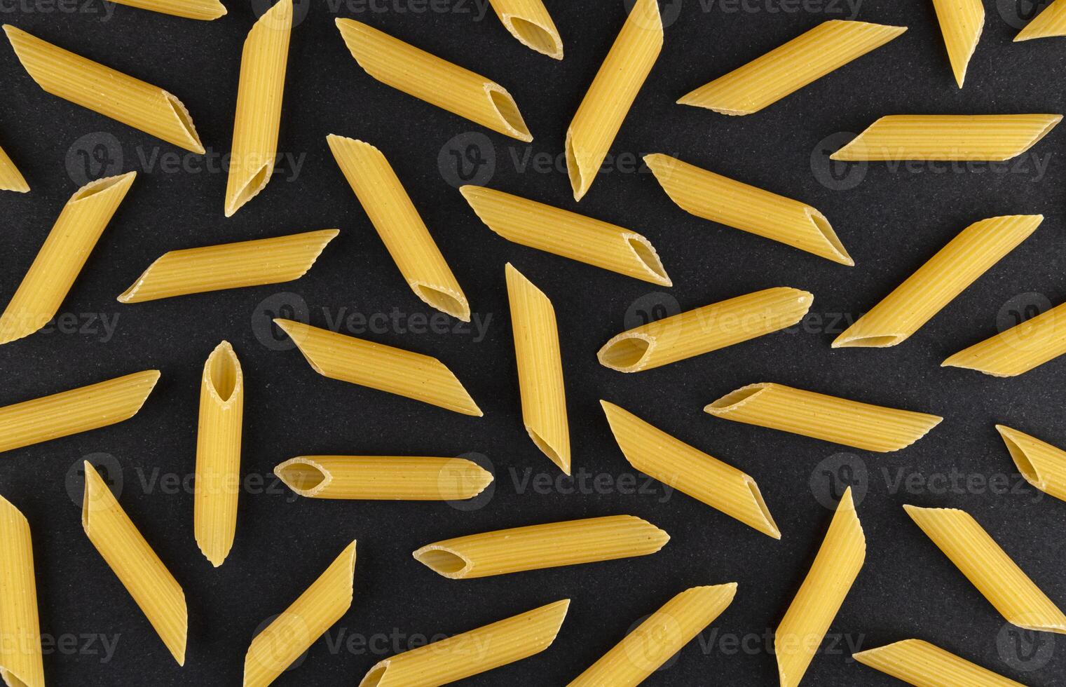 Penne rigate pasta pattern on black background, top view, flat lay texture photo