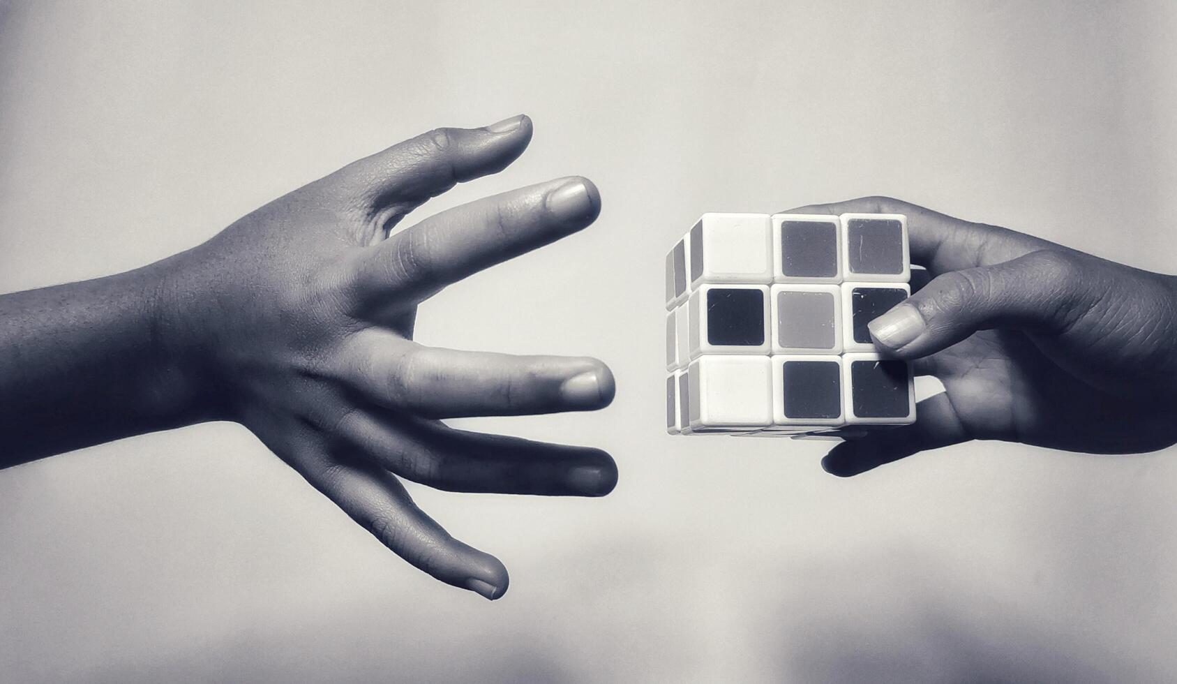 MAGELANG, INDONESIA. April 25th, 2024 - Man holding rubik's cube, the rubik's cube puzzle shadow concept on white background. photo