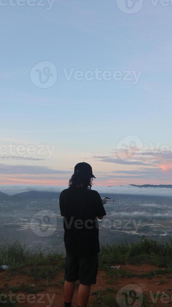 A Man Enjoying the Morning Atmosphere on Arang Hill, Gorontalo photo