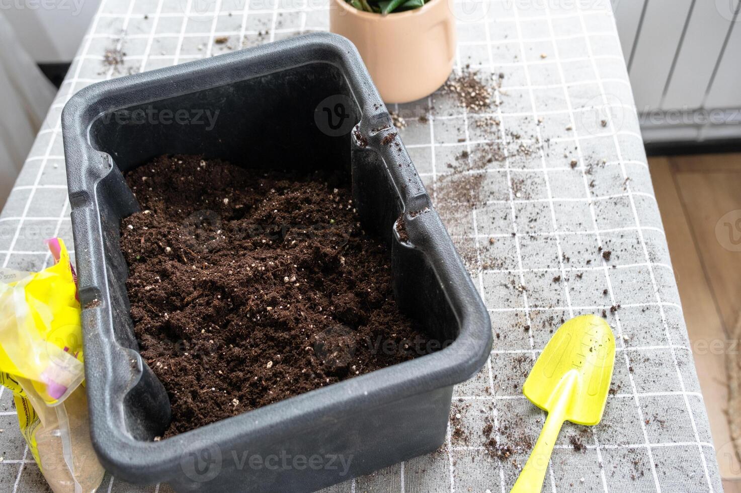Ingredients for the soil of home potted plants, peat, earth, sand, perlite, vermiculite, coconut. A mixture for planting plants in a pot florist's gloved hands are mixing in a container photo