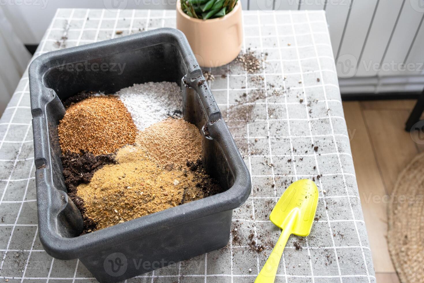 Ingredients for the soil of home potted plants, peat, earth, sand, perlite, vermiculite, coconut. A mixture for planting plants in a pot florist's gloved hands are mixing in a container photo