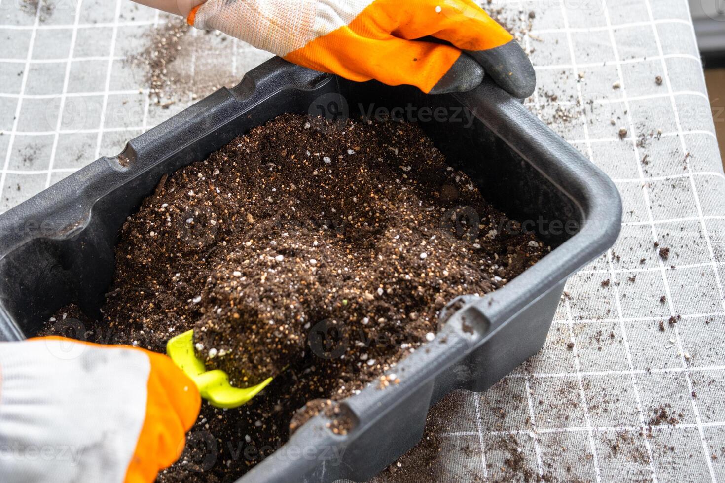 Ingredients for the soil of home potted plants, peat, earth, sand, perlite, vermiculite, coconut. A mixture for planting plants in a pot florist's gloved hands are mixing in a container photo
