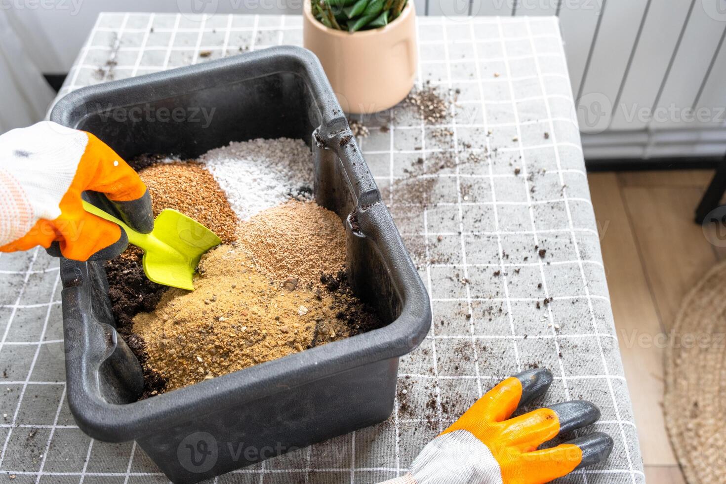 Ingredients for the soil of home potted plants, peat, earth, sand, perlite, vermiculite, coconut. A mixture for planting plants in a pot florist's gloved hands are mixing in a container photo