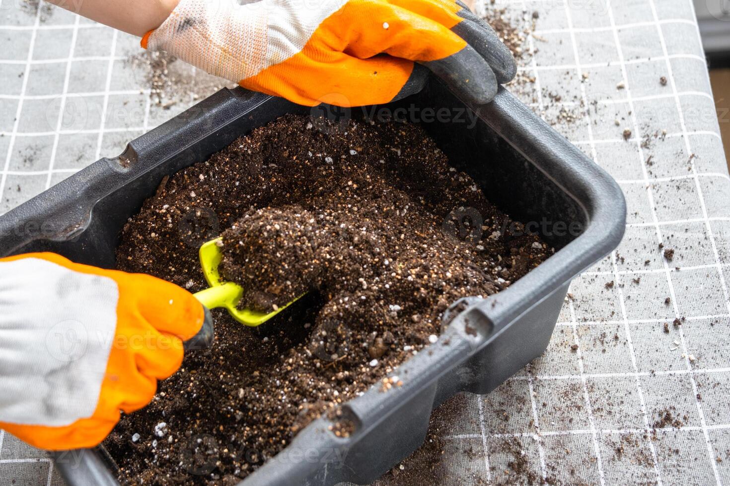 Ingredients for the soil of home potted plants, peat, earth, sand, perlite, vermiculite, coconut. A mixture for planting plants in a pot florist's gloved hands are mixing in a container photo