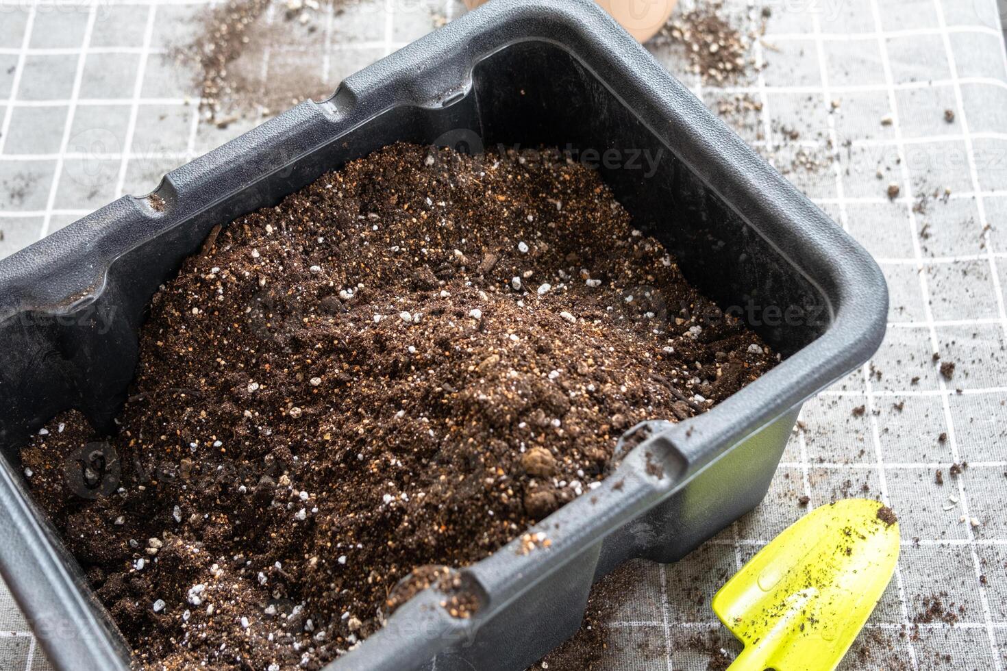Ingredients for the soil of home potted plants, peat, earth, sand, perlite, vermiculite, coconut. A mixture for planting plants in a pot florist's gloved hands are mixing in a container photo