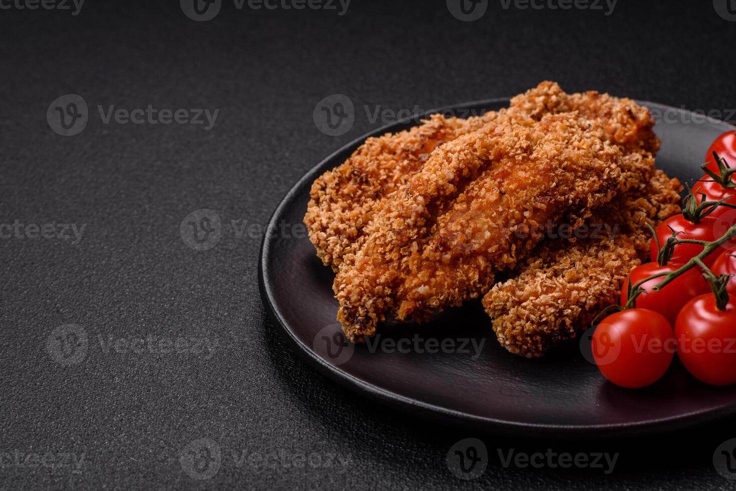 Delicious fresh crispy chicken nuggets on a dark concrete background photo
