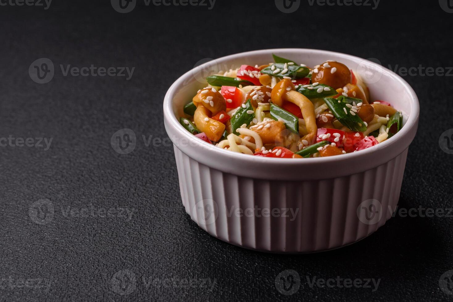 Delicious Asian cuisine dish with rice noodles, peppers, mushrooms and spices photo
