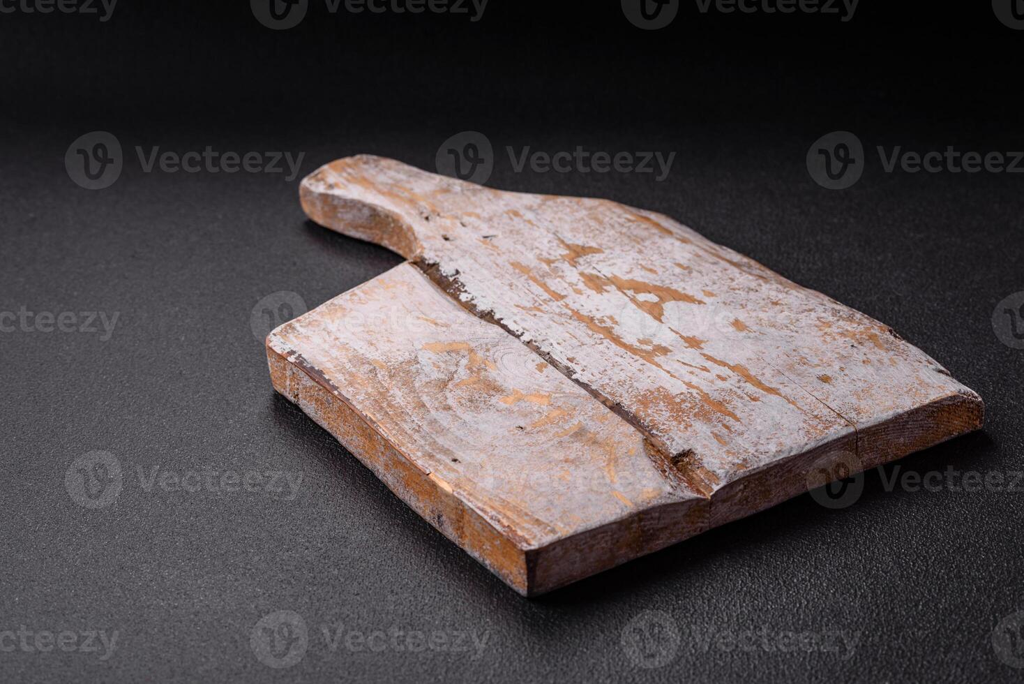 Empty wooden cutting board on dark textured concrete background photo