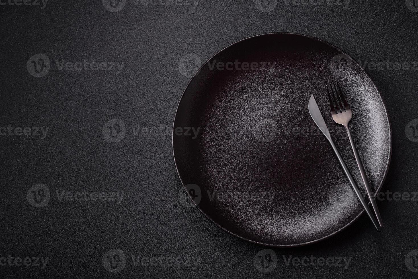 Empty ceramic round plate on dark textured concrete background photo