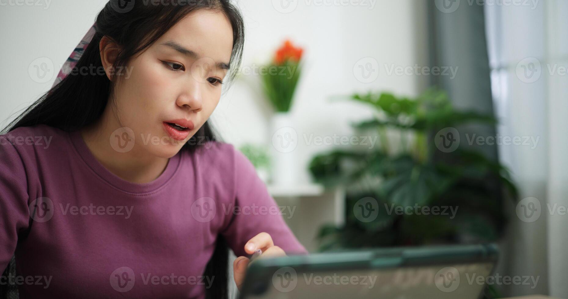 Portrait of Young asian businesswoman sitting at desk and having a call meeting on digital tablet at home office, online meeting for remote work photo