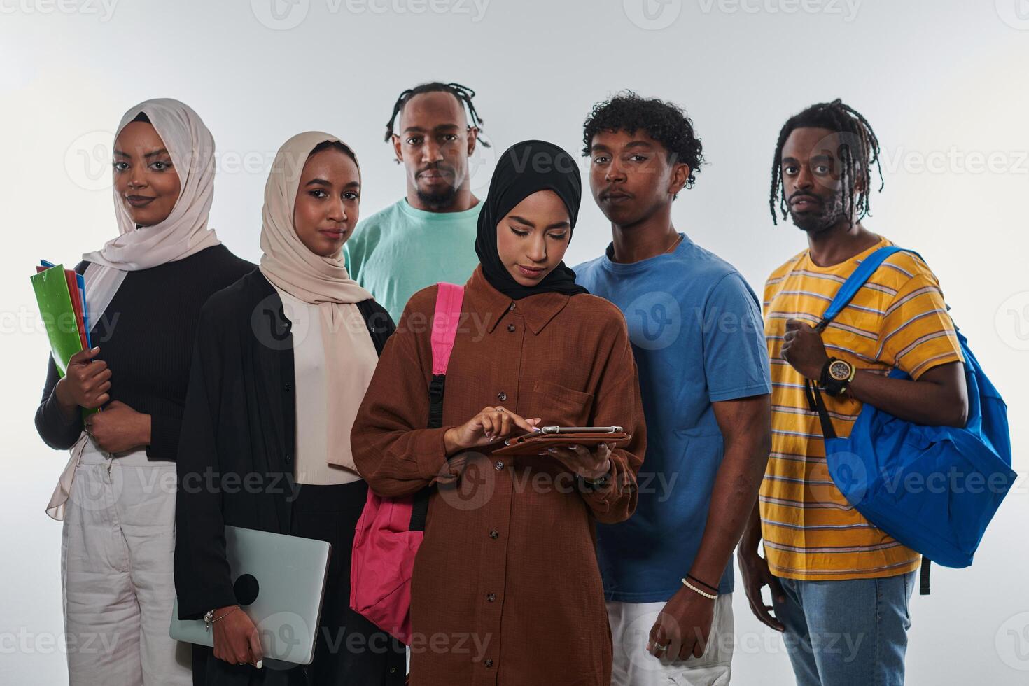 Group of diverse students engages in modern educational practices, utilizing a variety of technological tools such as laptops, tablets, and smartphones against a clean white background, exemplifying photo